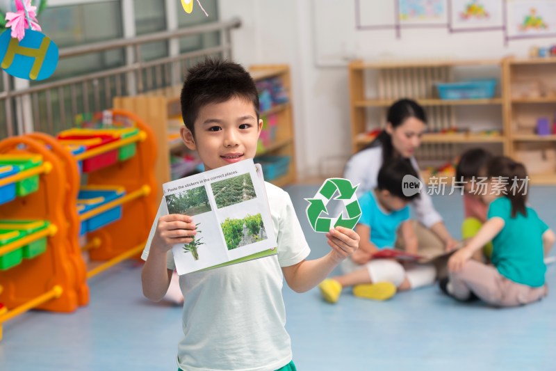 幼儿园儿童拿着环保标志