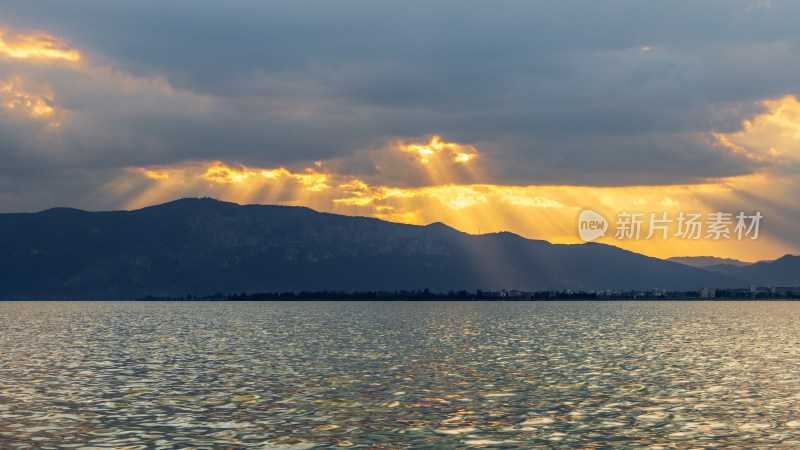 阳光穿透云层洒在湖面的自然美景