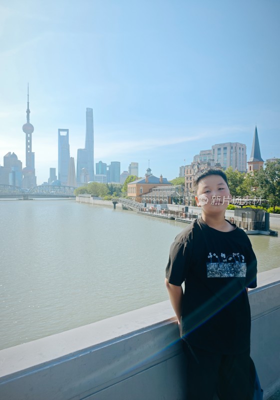 男孩于上海外滩畔的城市风景前留影