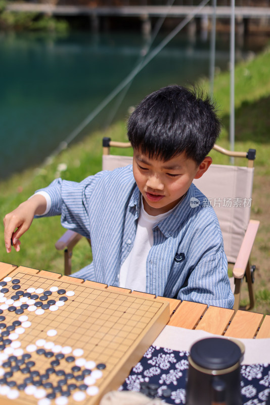 正在野外下棋的中国小男孩