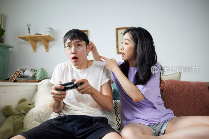 年轻情侣在家里玩游戏