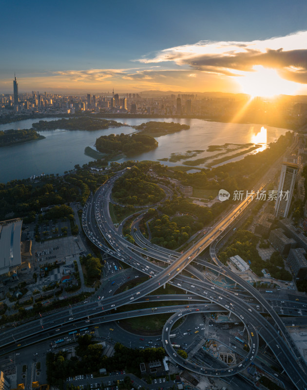 南京夕阳下城市立交桥与湖泊的航拍全景