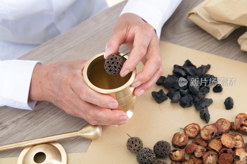 中医药师把风球子放进药臼里