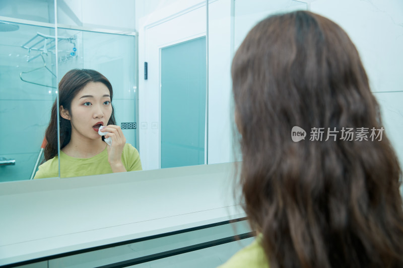 在卫生间对着镜子整理妆容的亚洲少女