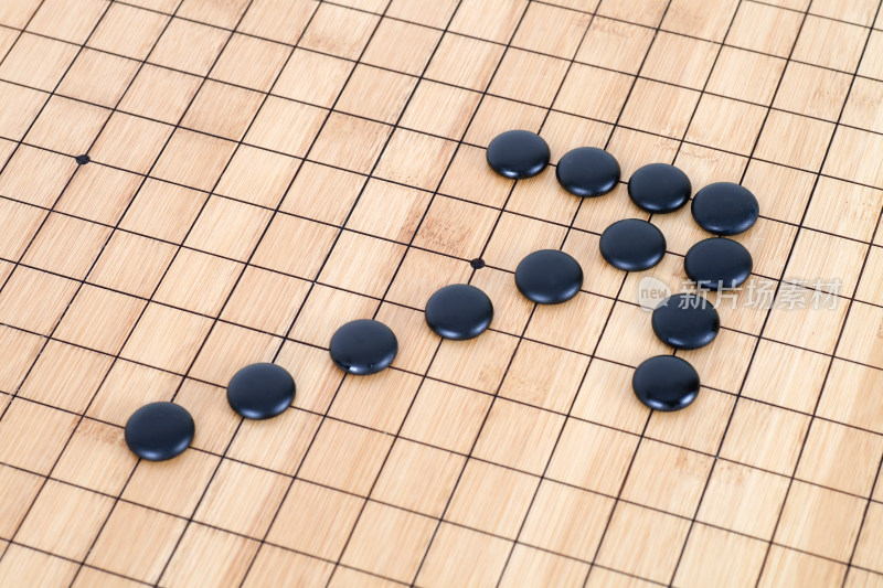 黑色围棋子棋盘上组成的箭头符号