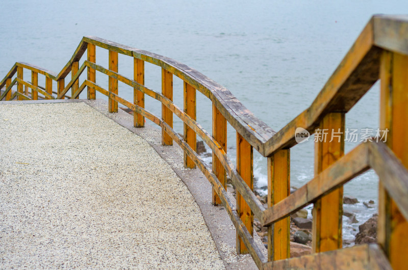 青岛小麦岛景区，向下延伸的海边木栏杆