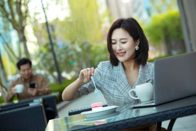 年轻女性坐在露天咖啡厅里