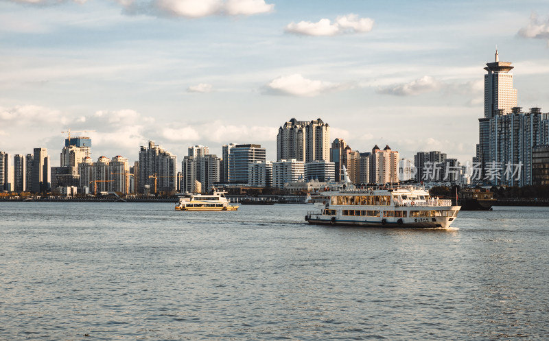 黄浦江上行驶的轮渡和远处的摩天大楼