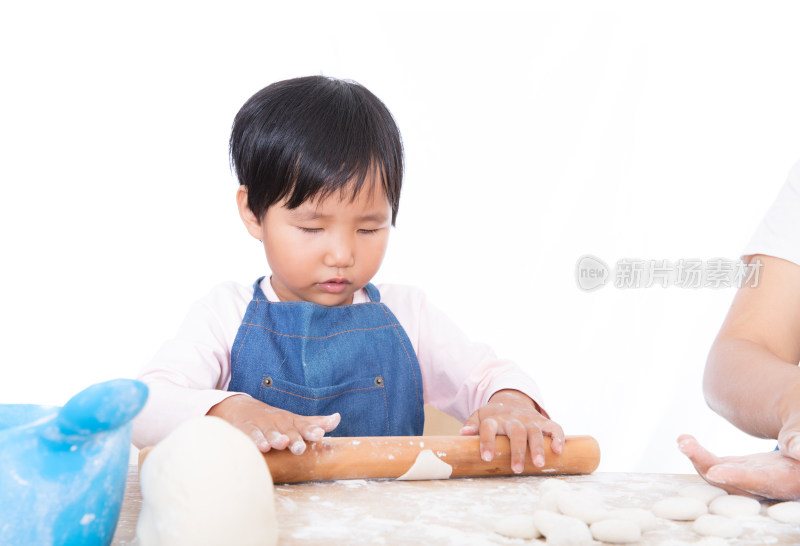 白背景前中国小女孩在学习压饺子皮