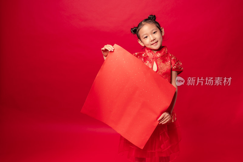 红色背景前穿旗袍拿空白门贴纸的中国女孩