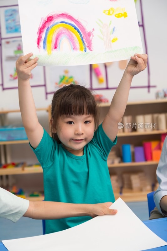 幼儿园女老师和儿童展示绘画作品