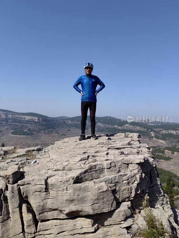 男子山顶站立眺望远方