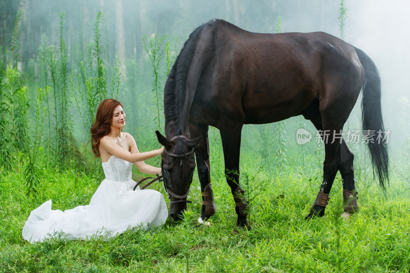 草地上穿着婚纱的青年女人和马
