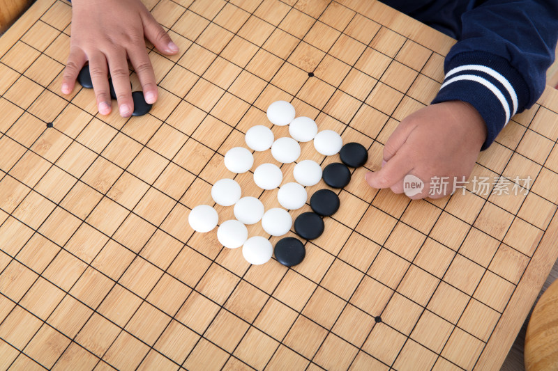 俯视拍摄小手在棋盘上下围棋