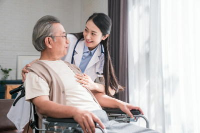 年轻的女医生在给老人做康复