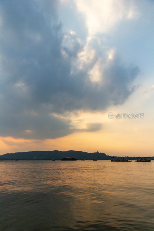 杭州西湖湖面夕阳下的山峦与云彩