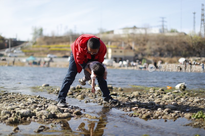 河边父亲与孩子嬉戏场景