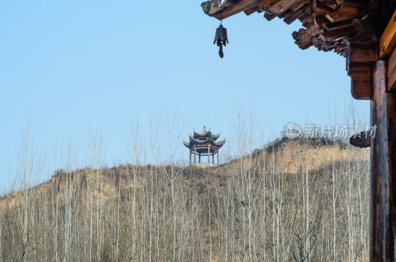 古建筑房檐和远处山坡上的亭子遥相呼应