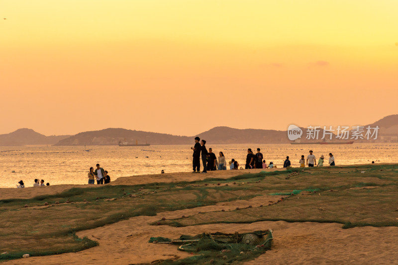 海边夕阳下的人群休闲场景