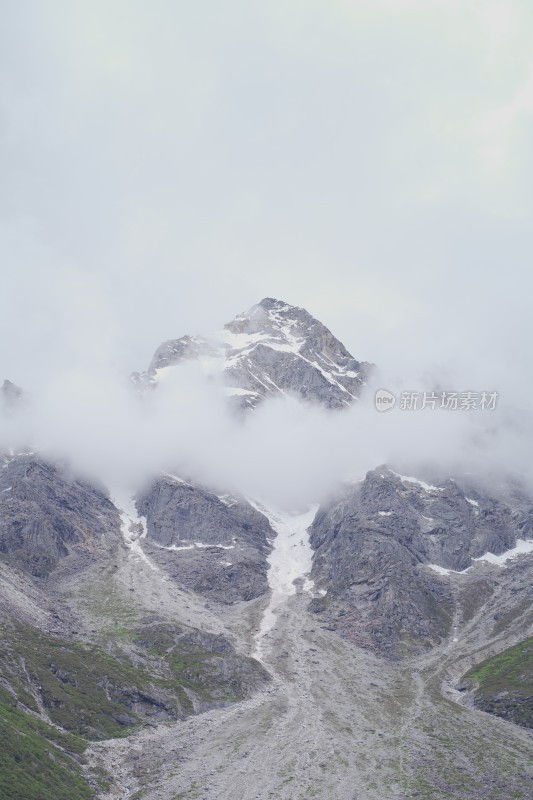 雨雾缭绕的雪山冒出山尖