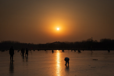 冰冻的湖面夕阳游客滑冰散步