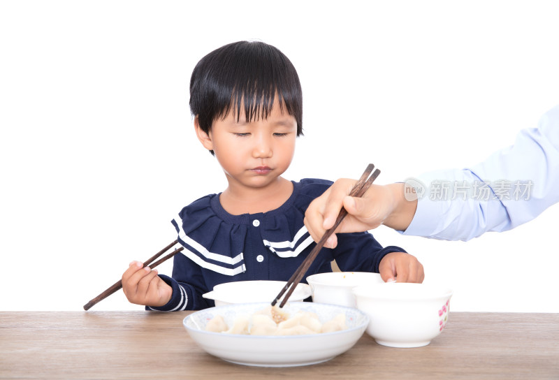 餐桌前妈妈在帮助自己的女儿吃饺子