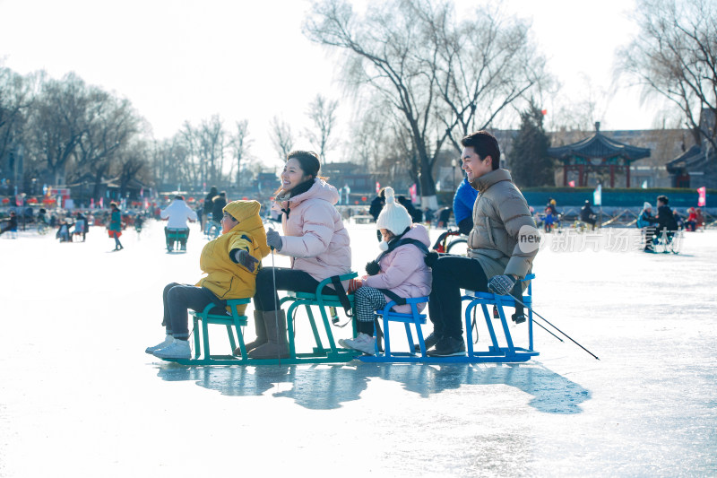 快乐的一家四口坐冰车玩耍