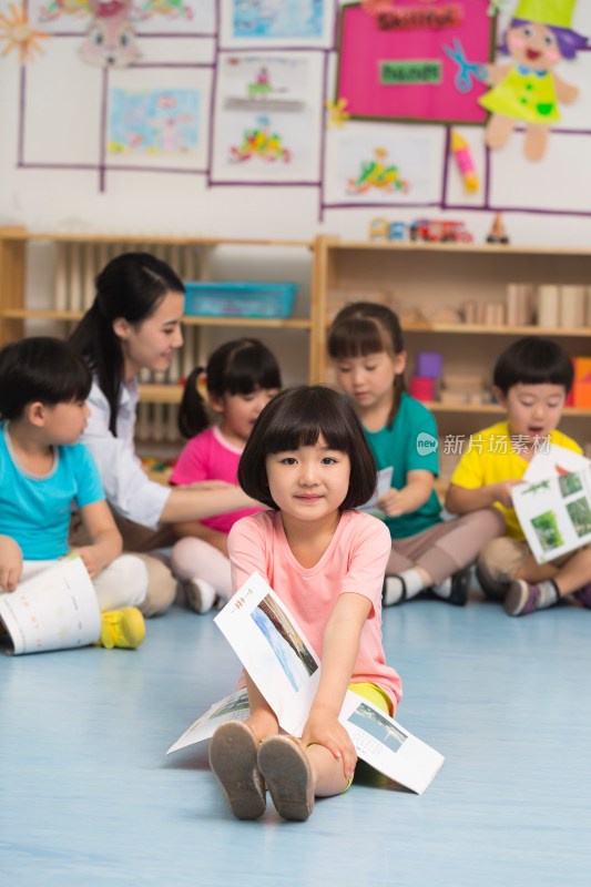 幼儿园儿童坐在地板上看故事书