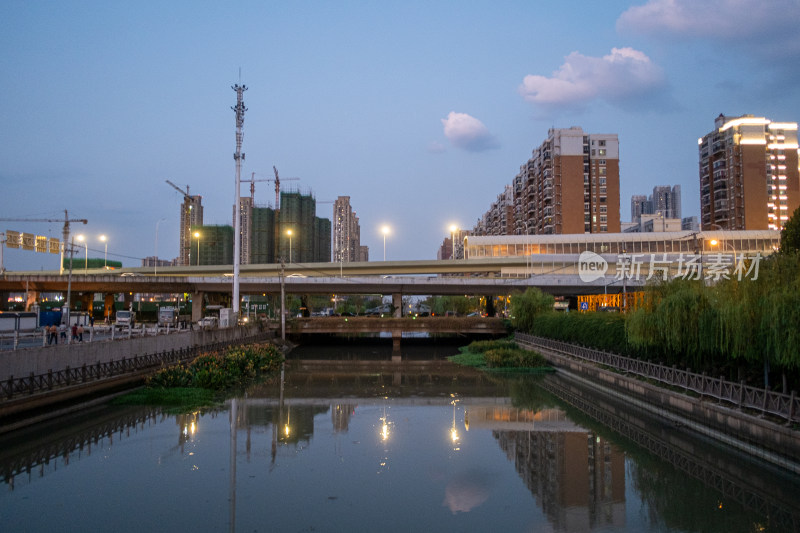 城市桥梁下的水域黄昏景象