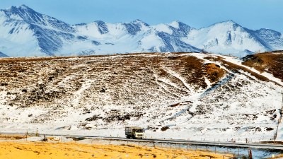 雪山背景下公路上行驶的货车