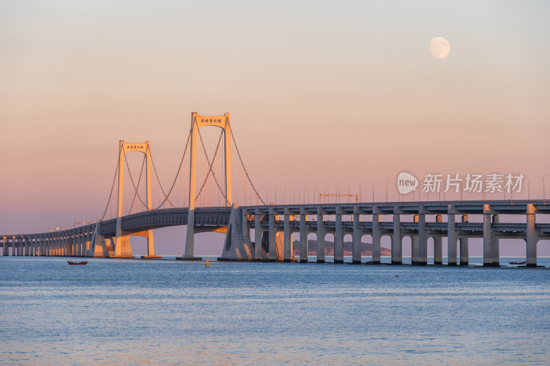 夕阳下大连星海湾大桥上空升起的月亮