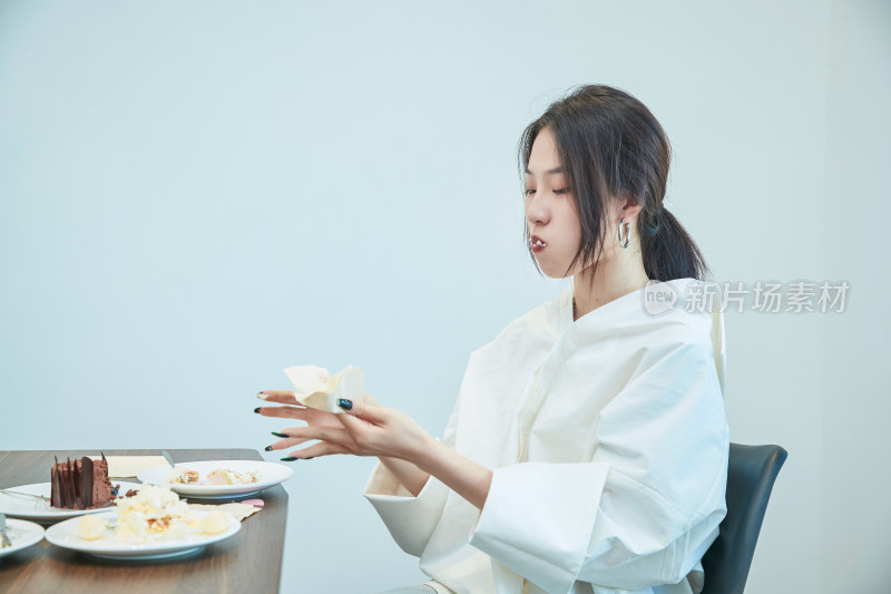 在烘焙店吃蛋糕喝饮料的可爱亚洲少女