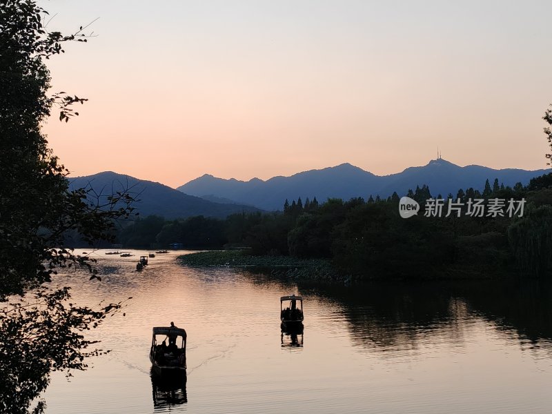 黄昏下的山水间小船悠悠的景象