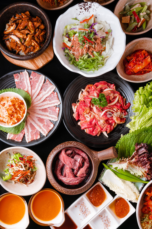 桌子上放满各式韩式烤肉和蔬菜