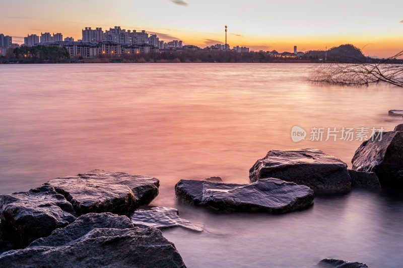 湖边日落景象，芦苇岩石相伴