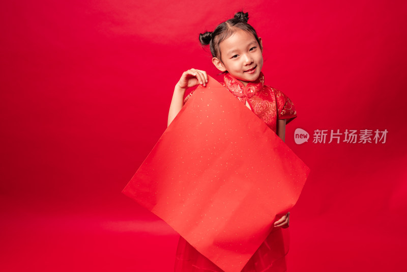 红色背景前穿旗袍拿空白门贴纸的中国女孩