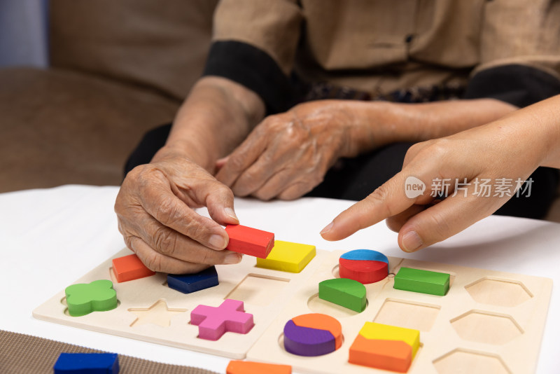 老人与他人一起玩拼图玩具