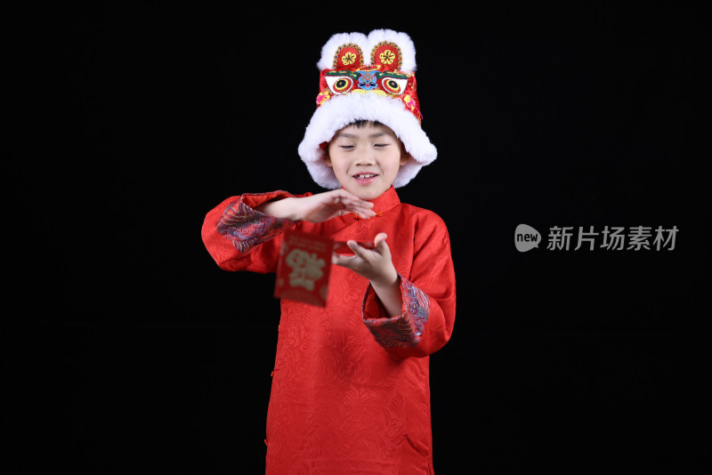 带虎头帽的中国小男孩和新年红包