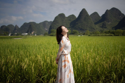 美丽的年轻女子在桂林旅行 站在稻田里