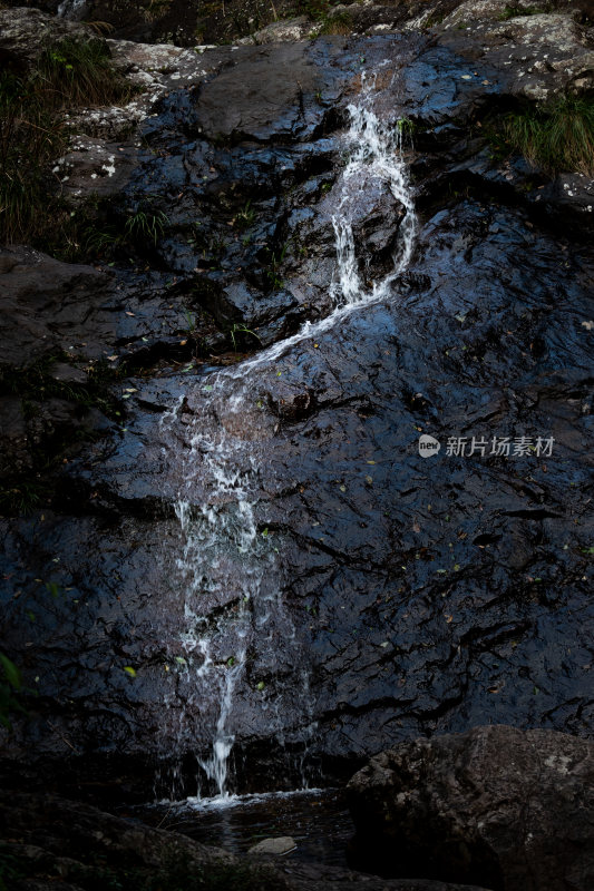 山间岩石上的小瀑布景观