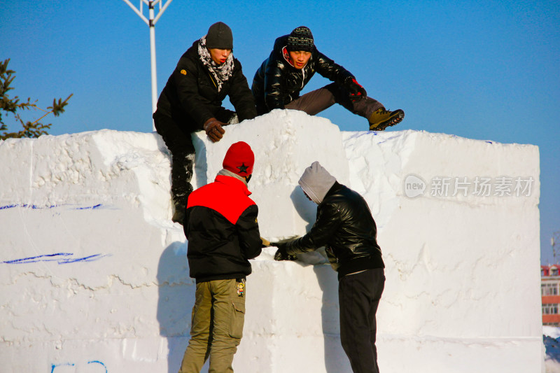 在哈尔滨人们户外合作制作大型雪雕