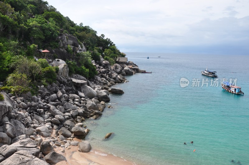 海岸边岩石与海上船只景观