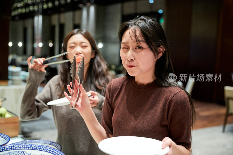 在酒店自助餐厅大吃特吃的亚洲可爱闺蜜少女