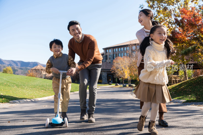 年轻夫妻带着孩子们在玩滑板车