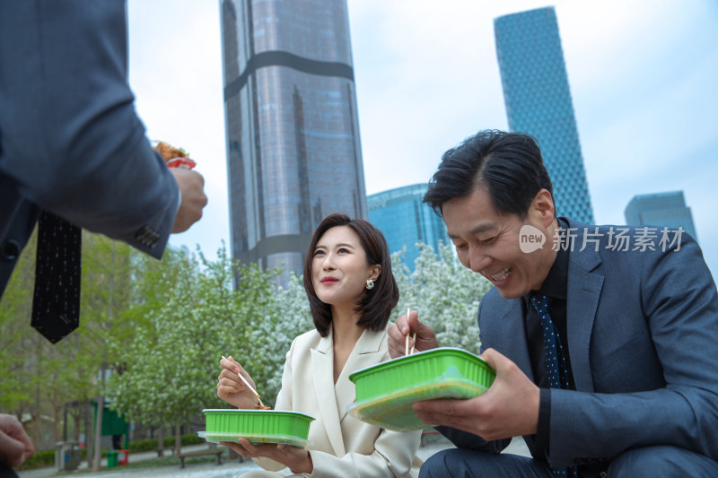 商务人士坐在户外吃盒饭