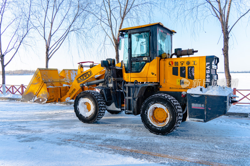 黄色装载机在积雪道路上作业