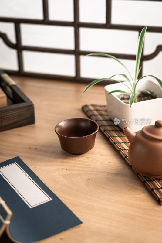 中式仿古窗前木质桌面上的紫砂壶