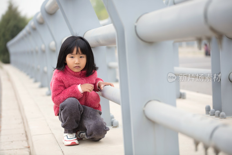 护栏旁边的五岁小姑娘