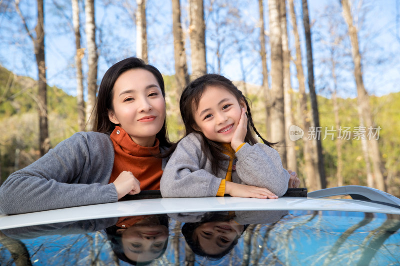 幸福的母女从汽车天窗伸出头来