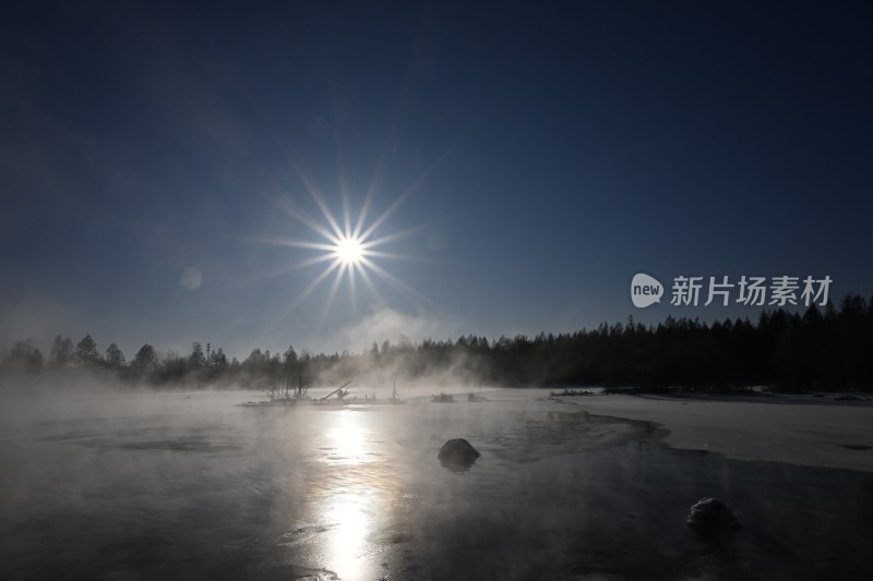 冬日湖面结冰雾气升腾太阳耀眼的景象